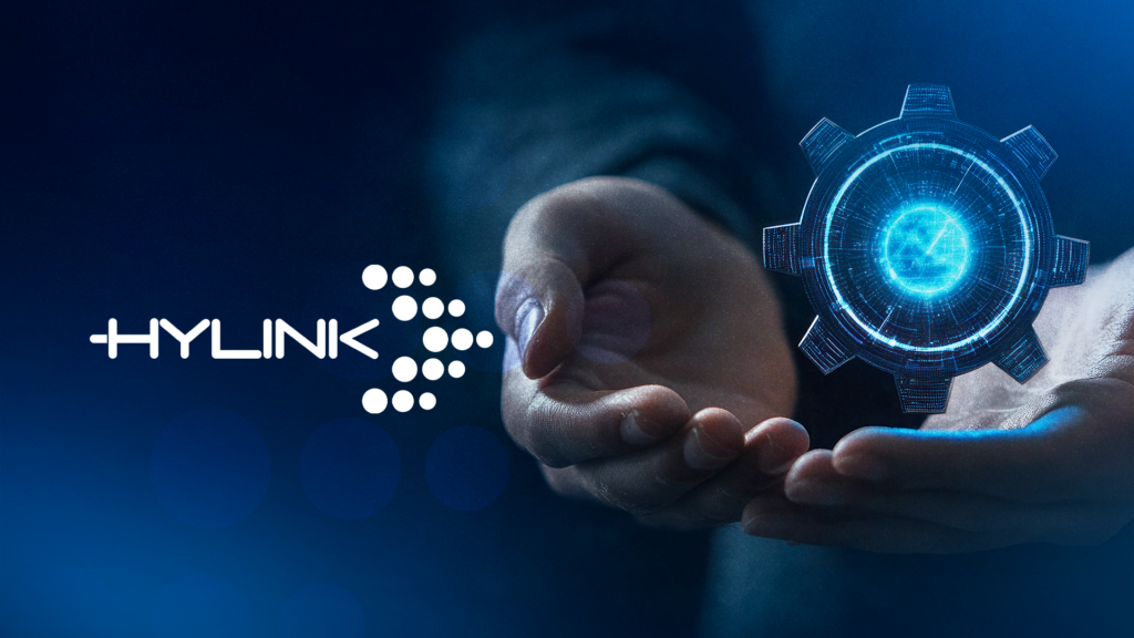 Imagem com fundo preto azul escuro com o logo da Hylink apontando para uma engrenagem que remete a Microsoft 365 virou infraestrutura de negócio.